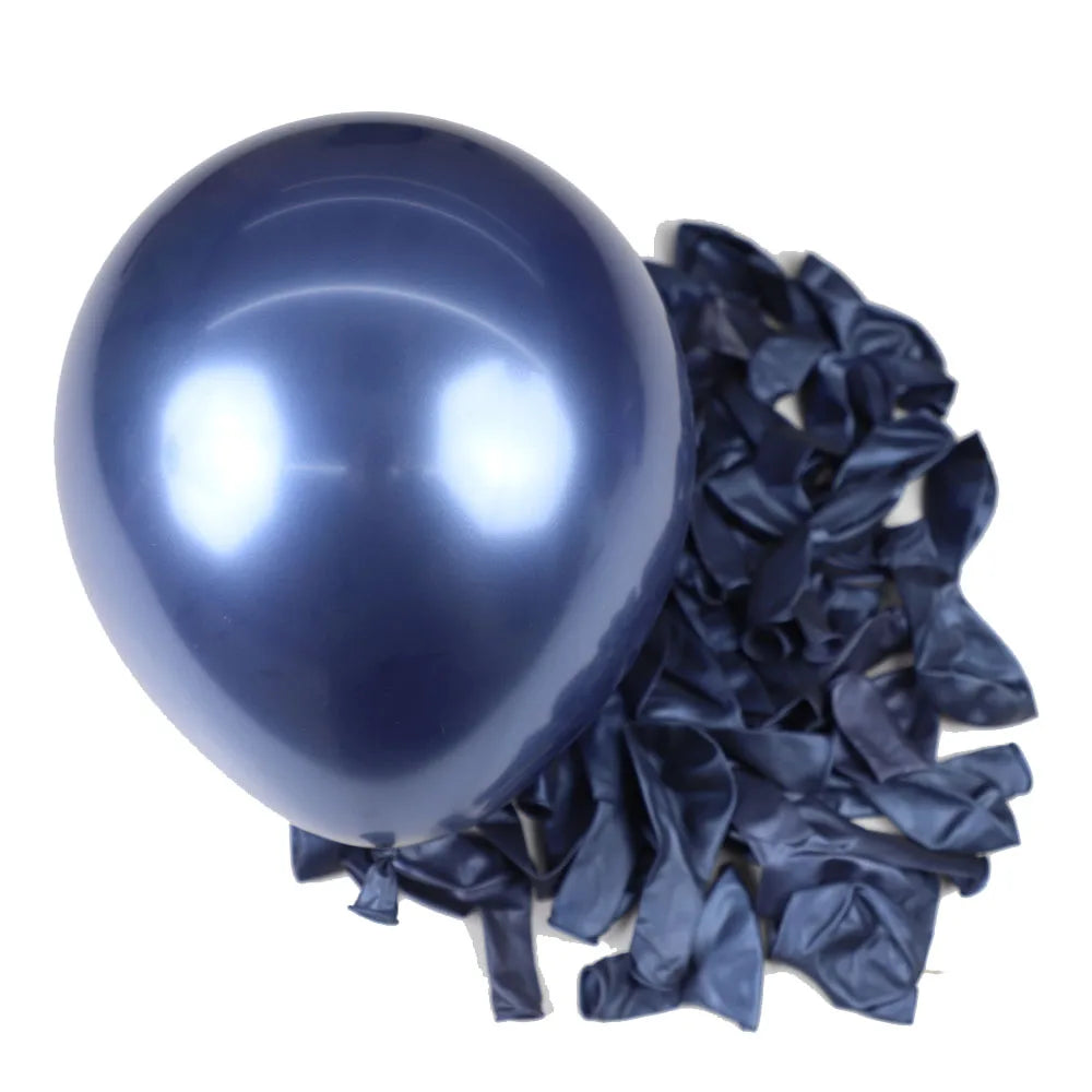 A single glossy dark blue latex balloon next to a pile of crumpled dark blue foil balloons for party decor.