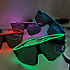 A pair of black party glasses with neon green and pink EL wire accents resting on a white surface.