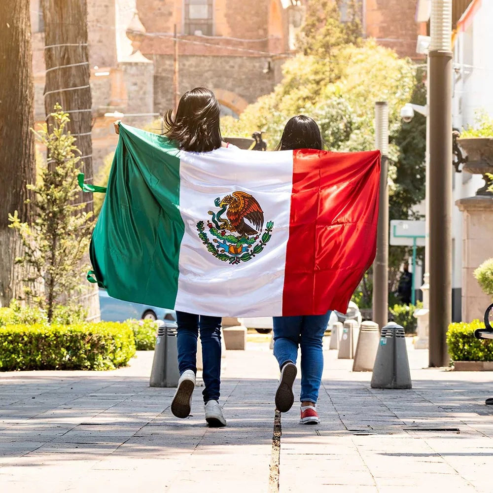 A person is holding a large Mexican flag made of durable polyester outdoors.