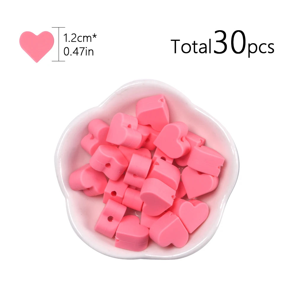 A pile of pink silicone heart beads for DIY jewelry making, totaling 30 pieces.
