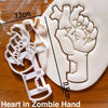 White fondant cookie cutter shaped like a zombie hand, shown next to a measuring scale.
