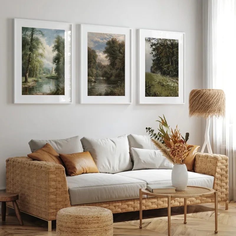 A gallery wall featuring three framed landscape paintings of nature and trees on a white wall.