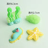 A set of five pastel-colored ocean animal cake toppers including a crab, turtle, octopus, whale, and starfish