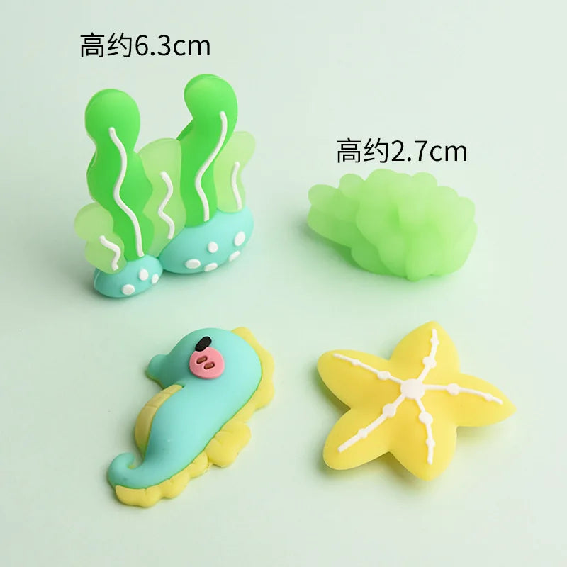A set of five pastel-colored ocean animal cake toppers including a crab, turtle, octopus, whale, and starfish