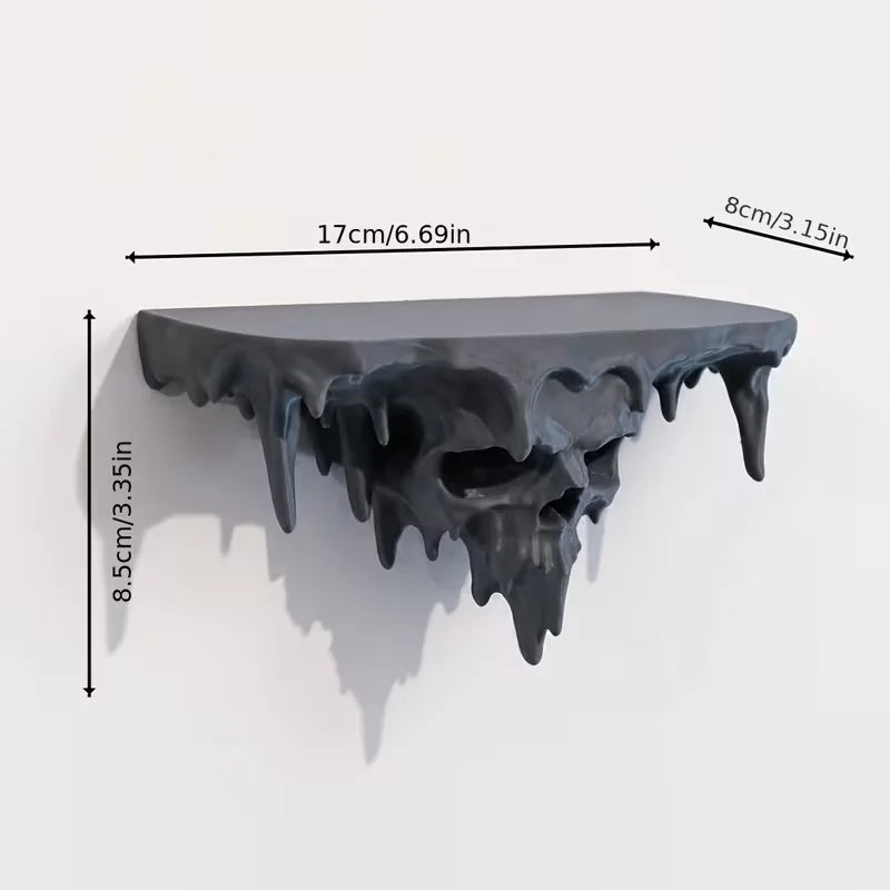 A dark gray melted skull wall shelf with dripping edges, shown against a white background.