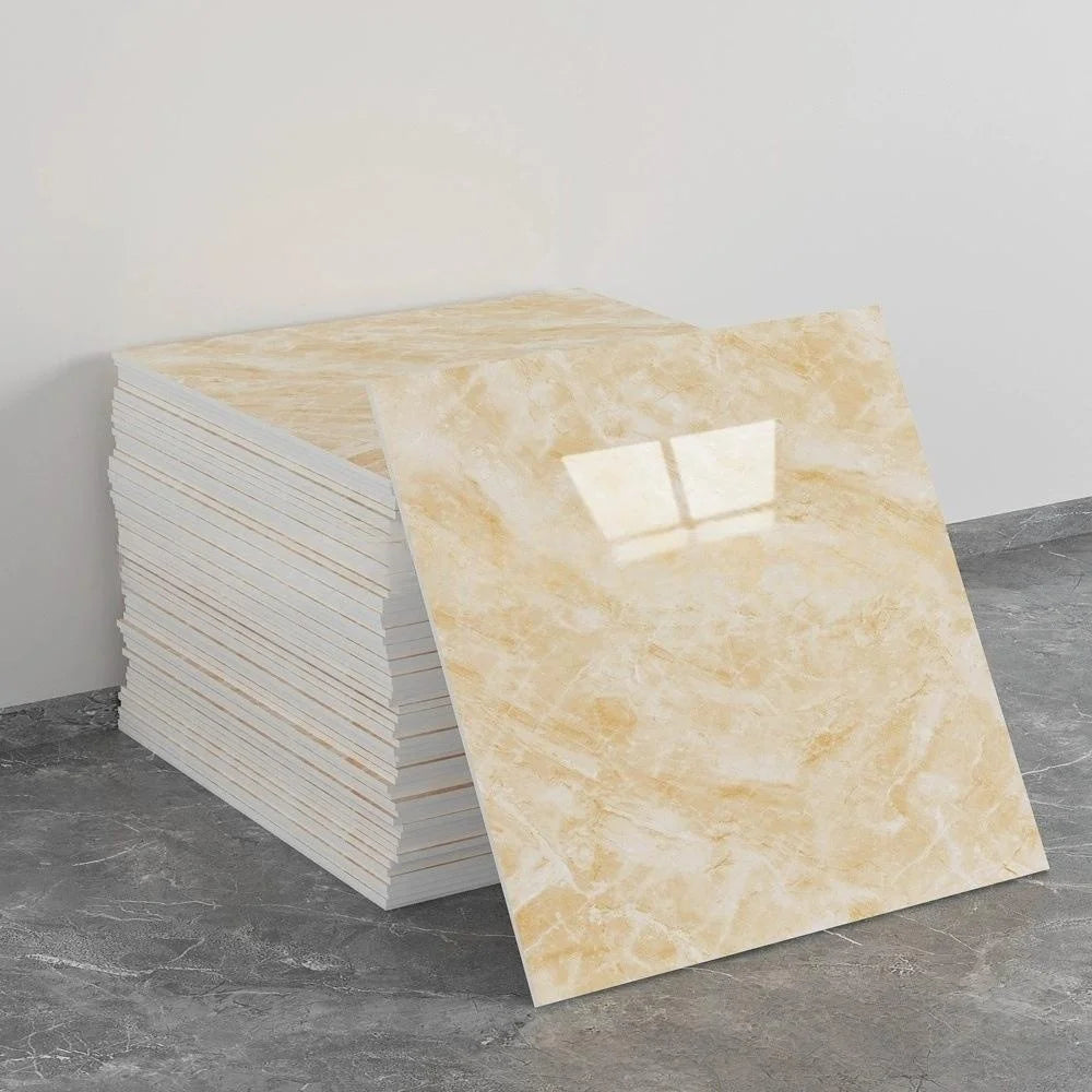 A rectangular sheet of light beige marble tile sticker placed next to a stack of white tiles on a gray floor.