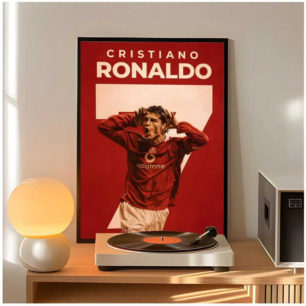 A framed poster of Cristiano Ronaldo in a red shirt hangs on a wall next to a modern lamp and audio equipment.