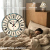 A round wooden wall clock with Roman numerals is displayed on a bed next to a wooden cabinet.