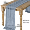 A semi-sheer sage green gauze table runner draped over a wooden table.