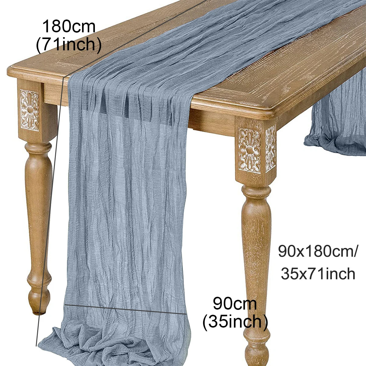 A semi-sheer sage green gauze table runner draped over a wooden table.