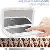 A portable touch screen makeup mirror showing a slider for adjusting brightness, with close-ups of a woman's face.
