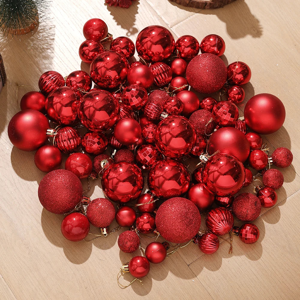 A cluster of assorted red and gold glitter Christmas tree ornaments scattered on a light wooden surface.