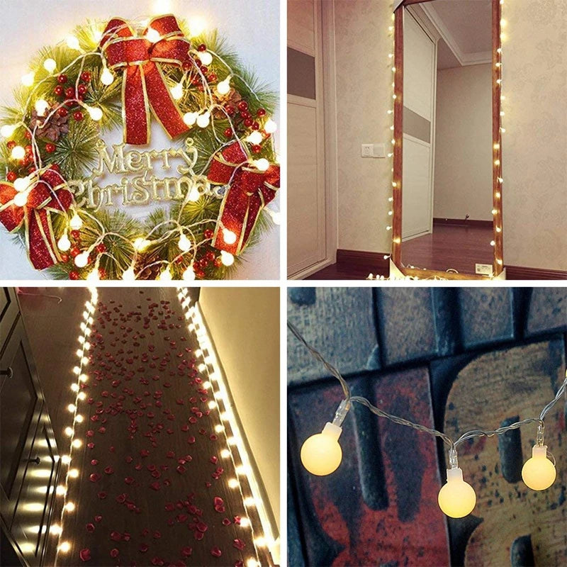 A festive wreath decorated with red ribbon and lights, a fireplace mantel display of string lights, and a garland of globe li