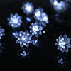 Close-up of bright white solar decorative string lights glowing against a dark background.