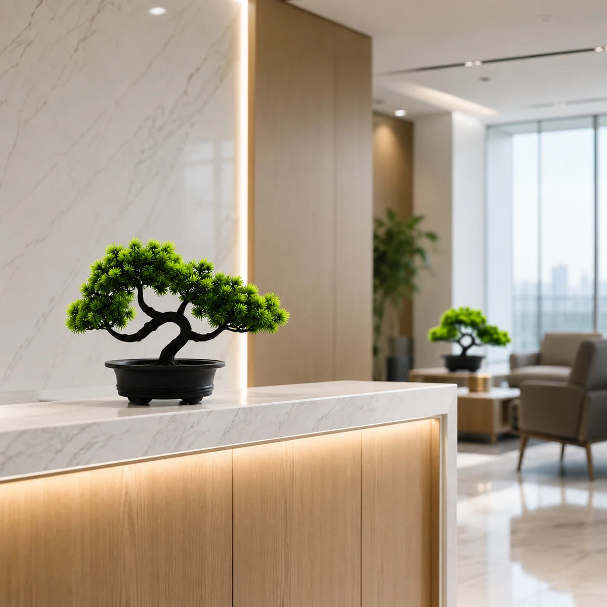 An artificial bonsai pine tree in a black pot displayed on a modern light-colored countertop.