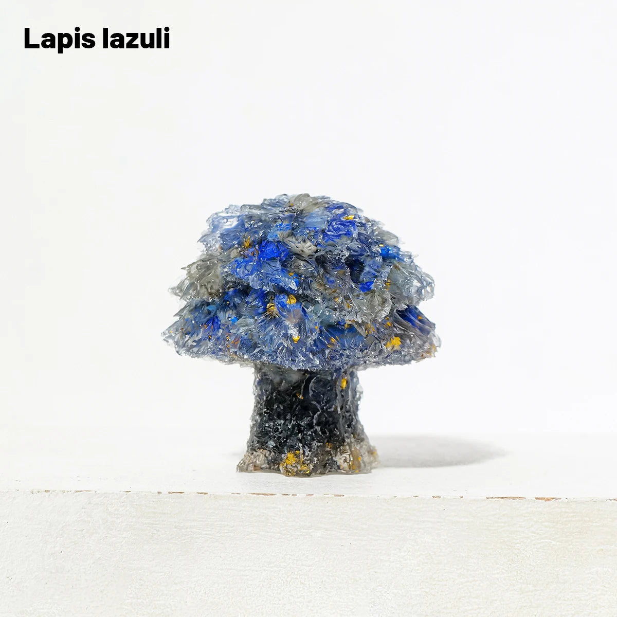 A natural crystal mushroom tree sculpture featuring blue lapis lazuli crystals on a dark base.