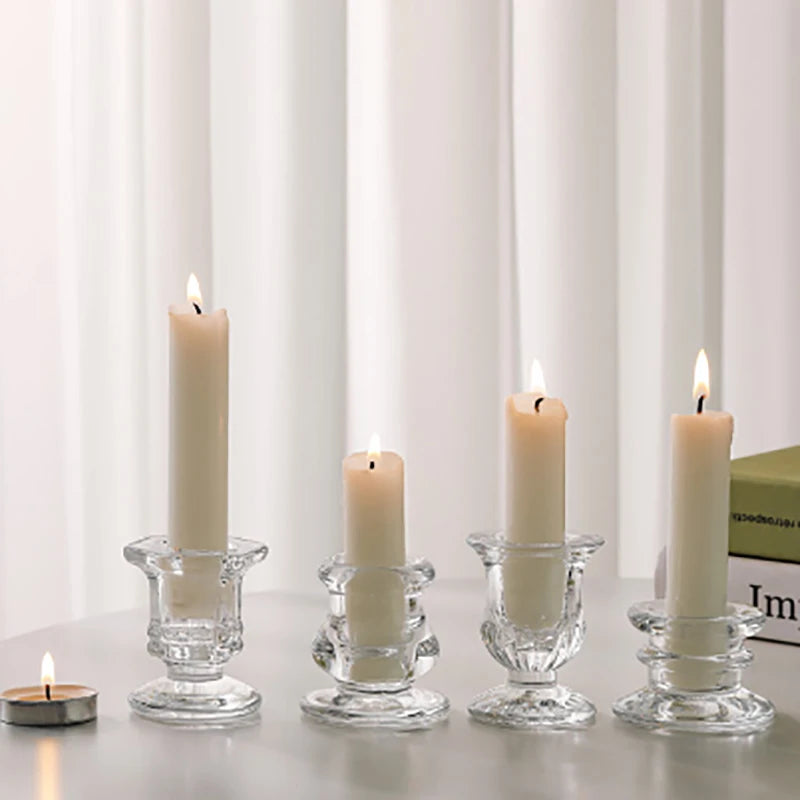 A row of tall white candles in clear glass holders on a gray surface.