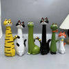 A collection of seven cat-shaped resin figurines in various colors including yellow black white green and orange