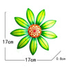 Escultura de flor de metal verde vibrante con un núcleo central naranja-rojo y pétalos detallados.