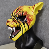A yellow latex mask resembling a tiger's face with blood splatters and teeth, displayed on a black bust.