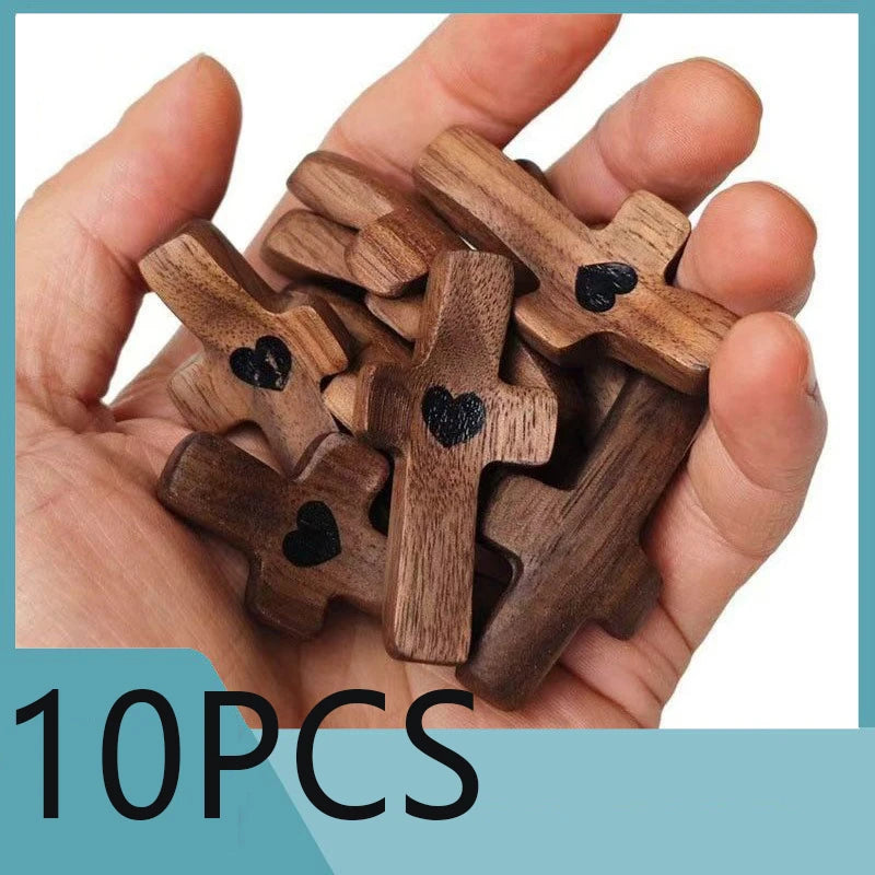 A hand holds a cluster of ten wooden crosses with epoxy hearts for spiritual comfort.
