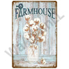 A rustic metal sign featuring the word FARMHOUSE and a bouquet of dried white flowers in a glass jar.