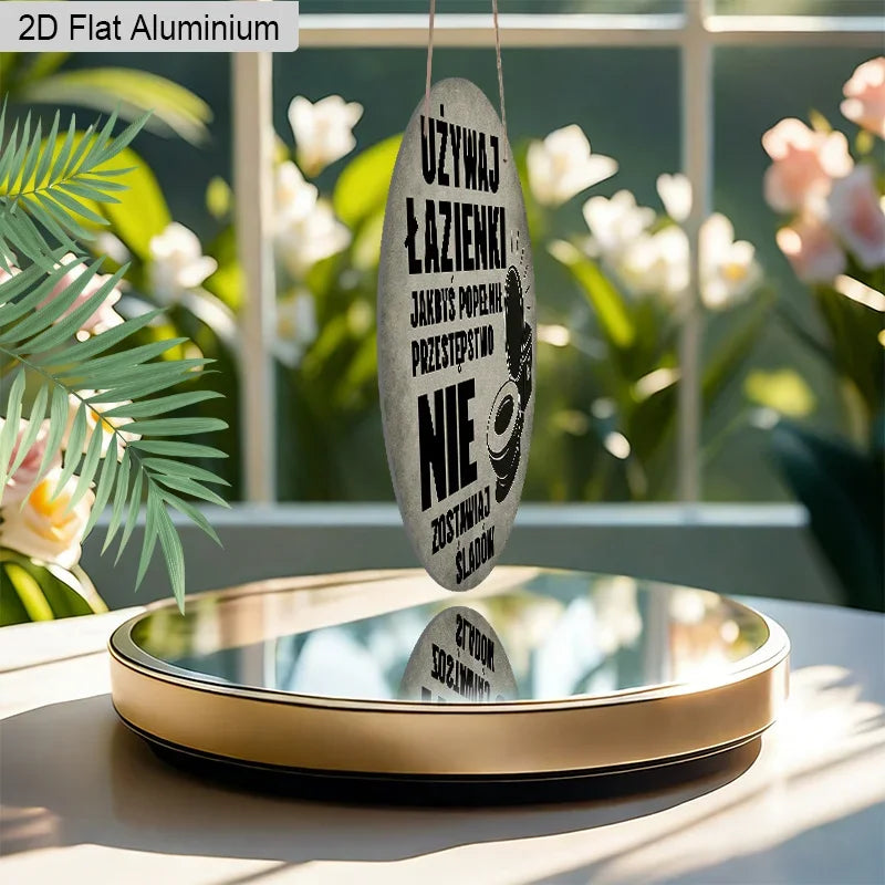A hanging sign made of 2D flat aluminum with Polish text, displayed on a reflective surface.