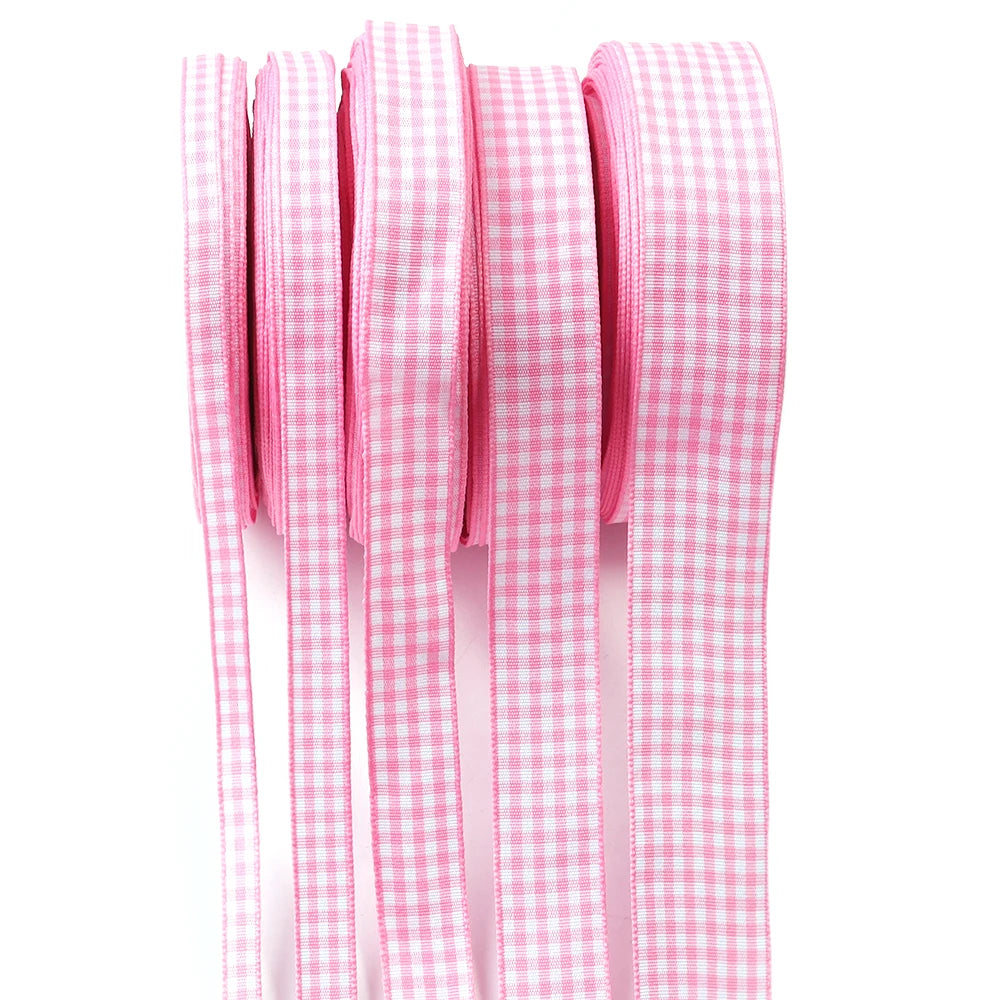 Pink gingham ribbon rolls stacked vertically for gift wrapping and party decor