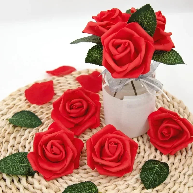 A bouquet of realistic red foam rose flower heads with green leaves tied with a white ribbon.
