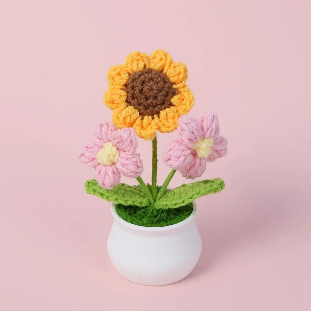 Handmade knitted orange and pink flowers in a white pot