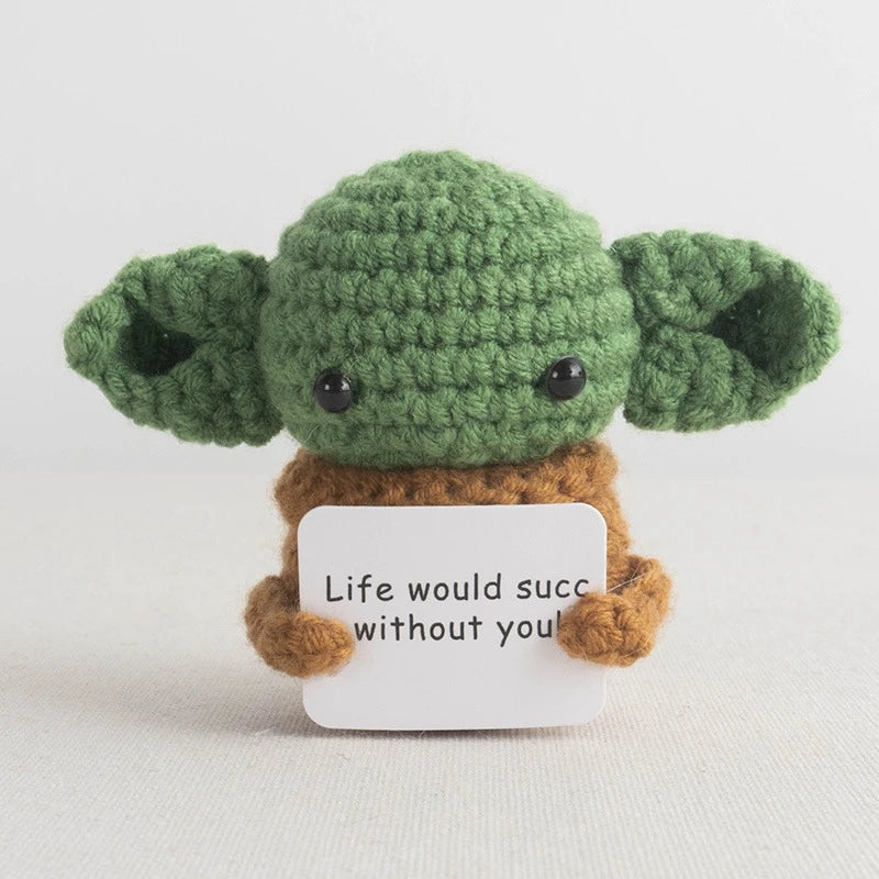 Handmade crochet potato doll with green skin and brown features, featuring an inspirational slogan tag.