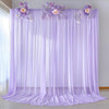 Purple chiffon backdrop curtain with floral accents used for wedding and event decor
