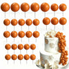 A set of round orange foam cake toppers displayed on white sticks.