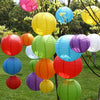 A collection of colorful round paper lanterns in various shades including pink, yellow, blue, green, orange, and red hanging 