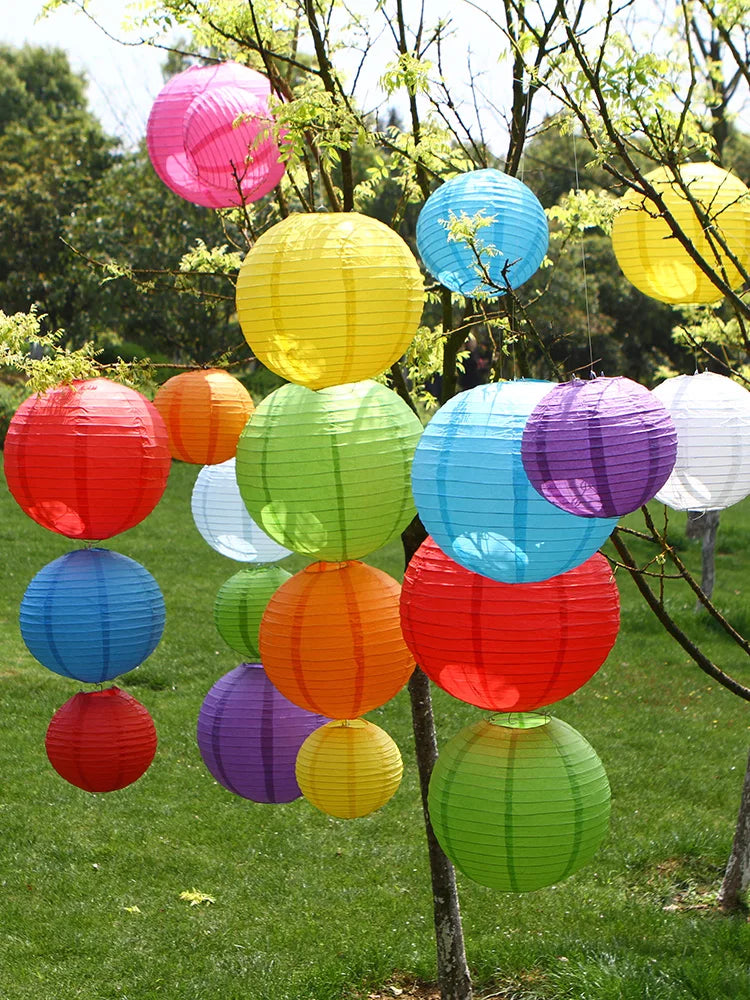 A collection of colorful round paper lanterns in various shades including pink, yellow, blue, green, orange, and red hanging 