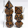 A set of seven polyhedral dice in black and orange colors arranged vertically.