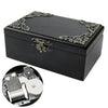 A black hand-cranked wooden music box with ornate gold detailing and an open mechanism shown separately.