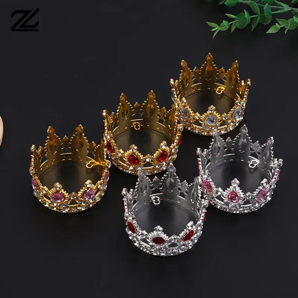 A collection of five gold and silver tiara crowns used as cake toppers or hair accessories.