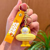A golden keychain pendant shaped like a cartoon Garfield character with yellow fur and orange features.