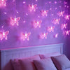 Purple wall decorated with hanging LED butterfly lights illuminating a bedroom