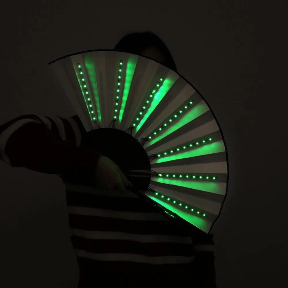 شخص يحمل مروحة ضوئية حريرية LED قابلة للطي، تصدر أشعة خضراء ساطعة.