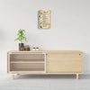 A wooden cabinet displaying a framed piece of Spanish Psalm 91 canvas wall art with green foliage.