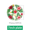 A plate featuring a tropical floral pattern of pink and red hibiscus flowers on a green background.