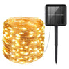 A spool of warm yellow fairy string lights with a black solar panel attached for outdoor decoration.