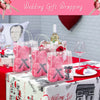 Clear reusable PVC gift bags with pink floral designs displayed on a table setting.