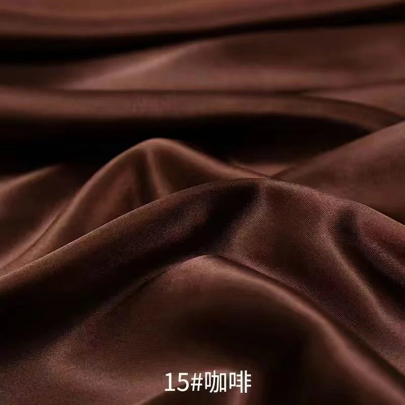 Close-up of dark brown satin fabric draped and folded