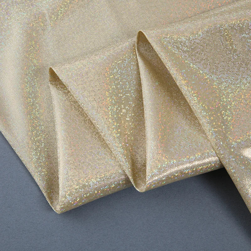 A close-up of a gold sequin fabric curtain draped and folded for photography or events.