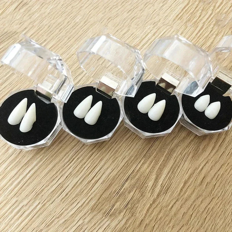 Realistic vampire fangs with adjustable fit displayed on clear plastic holders.
