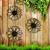 Black metal silhouette of a sunflower wall decor set mounted on weathered wooden planks with green vines.