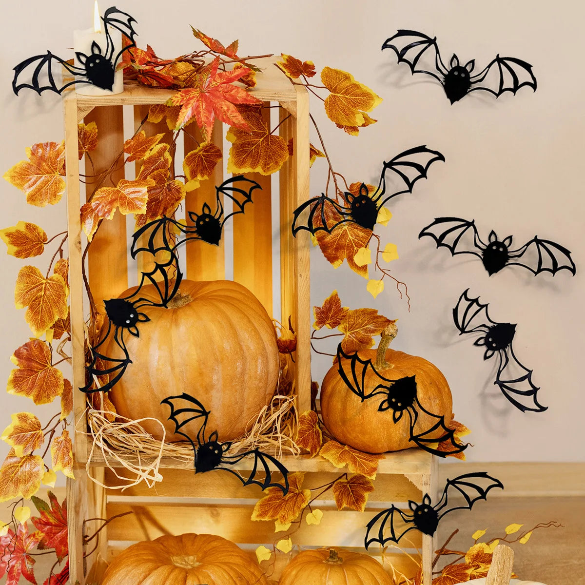 A wooden pumpkin display featuring black bat wall decals and autumn leaves.